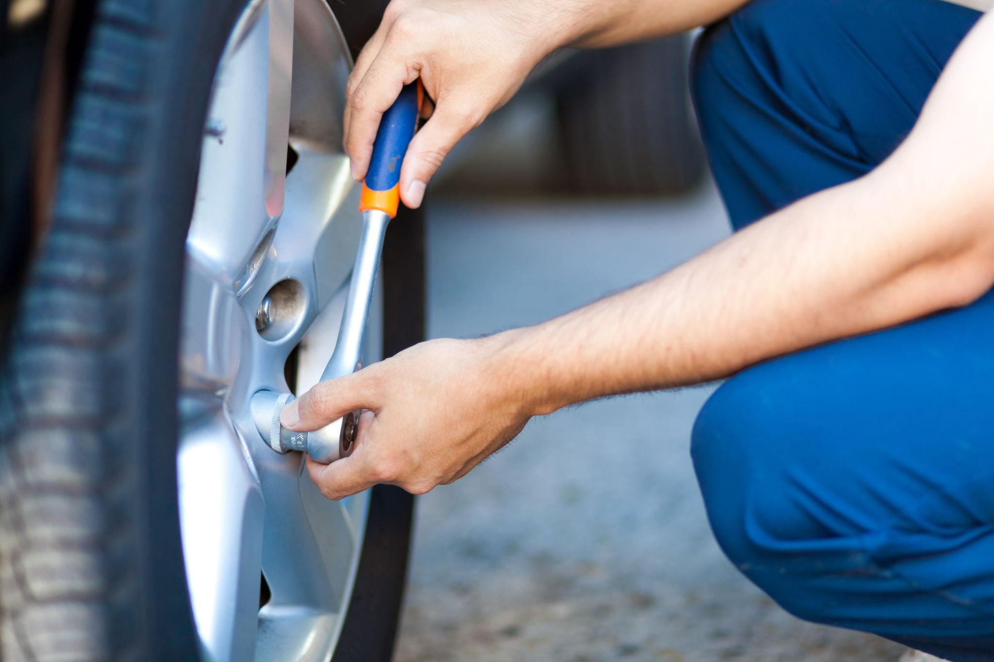 Auto mechanic in his workshop changing tires or rims